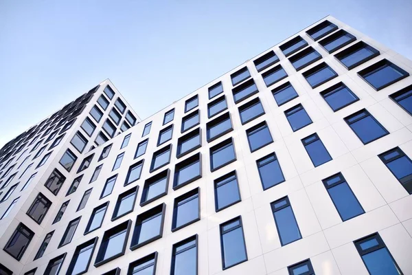 Modern European building. White building with many windows against the blue sky. Abstract architecture, fragment of modern urban geometry.