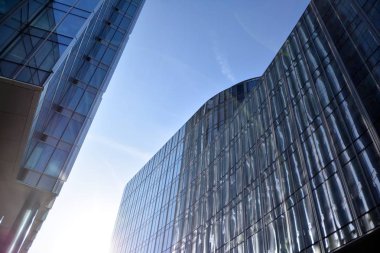 Çelik ve cam mavi gökyüzü ile modern ofis binası duvar yapılmış