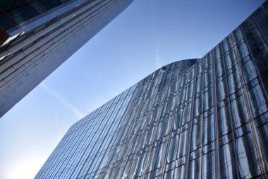 Çelik ve cam mavi gökyüzü ile modern ofis binası duvar yapılmış