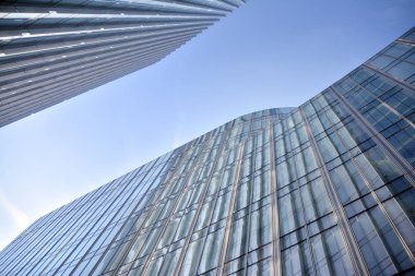 Çelik ve cam mavi gökyüzü ile modern ofis binası duvar yapılmış