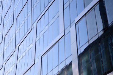 Çelik ve cam mavi gökyüzü ile modern ofis binası duvar yapılmış