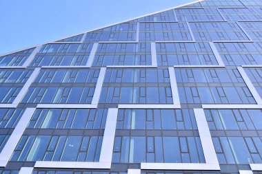 Çelik ve cam mavi gökyüzü ile modern ofis binası duvar yapılmış