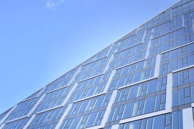 Çelik ve cam mavi gökyüzü ile modern ofis binası duvar yapılmış