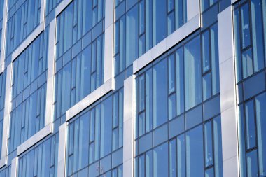 Çelik ve cam mavi gökyüzü ile modern ofis binası duvar yapılmış