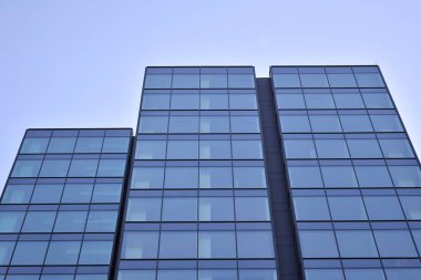 Çelik ve cam mavi gökyüzü ile modern ofis binası duvar yapılmış