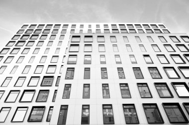 Modern Avrupa binası. Mavi gökyüzüne karşı birçok penceresi olan beyaz bir bina. Soyut mimari, modern şehir geometrisinin bir parçası. Siyah ve beyaz.