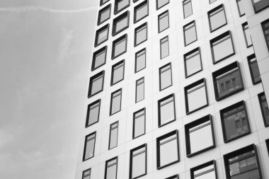 Modern Avrupa binası. Mavi gökyüzüne karşı birçok penceresi olan beyaz bir bina. Soyut mimari, modern şehir geometrisinin bir parçası. Siyah ve beyaz.