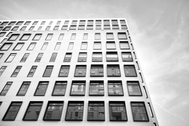 Modern Avrupa binası. Mavi gökyüzüne karşı birçok penceresi olan beyaz bir bina. Soyut mimari, modern şehir geometrisinin bir parçası. Siyah ve beyaz.