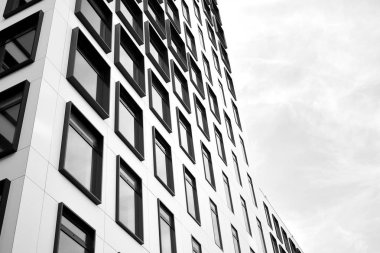 Modern Avrupa binası. Mavi gökyüzüne karşı birçok penceresi olan beyaz bir bina. Soyut mimari, modern şehir geometrisinin bir parçası. Siyah ve beyaz.