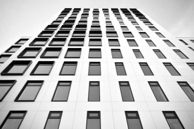 Modern Avrupa binası. Mavi gökyüzüne karşı birçok penceresi olan beyaz bir bina. Soyut mimari, modern şehir geometrisinin bir parçası. Siyah ve beyaz.