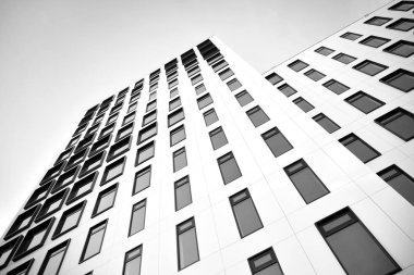 Modern Avrupa binası. Mavi gökyüzüne karşı birçok penceresi olan beyaz bir bina. Soyut mimari, modern şehir geometrisinin bir parçası. Siyah ve beyaz.