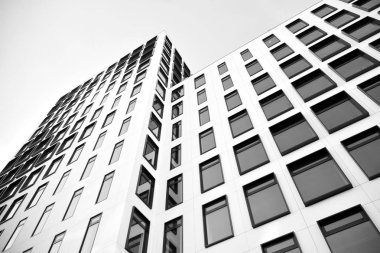 Modern Avrupa binası. Mavi gökyüzüne karşı birçok penceresi olan beyaz bir bina. Soyut mimari, modern şehir geometrisinin bir parçası. Siyah ve beyaz.