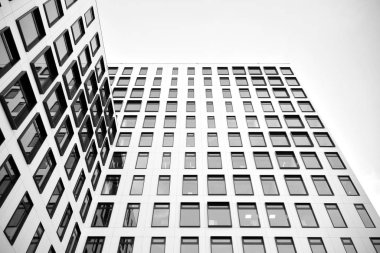 Modern Avrupa binası. Mavi gökyüzüne karşı birçok penceresi olan beyaz bir bina. Soyut mimari, modern şehir geometrisinin bir parçası. Siyah ve beyaz.