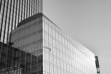 Çelik ve camdan yapılmış, mavi gökyüzü olan modern ofis duvarı. Siyah ve beyaz.