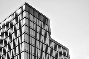 Çelik ve camdan yapılmış, mavi gökyüzü olan modern ofis duvarı. Siyah ve beyaz.