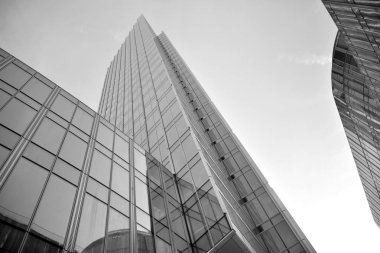 Çelik ve camdan yapılmış, mavi gökyüzü olan modern ofis duvarı. Siyah ve beyaz.