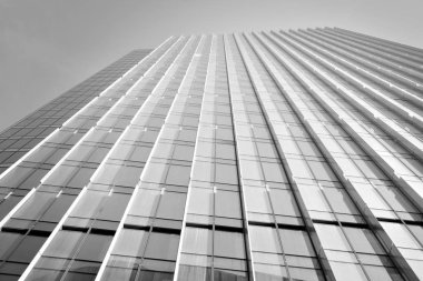 Çelik ve camdan yapılmış, mavi gökyüzü olan modern ofis duvarı. Siyah ve beyaz.