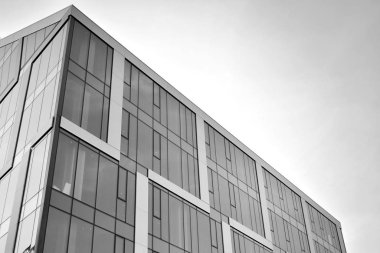 Çelik ve camdan yapılmış, mavi gökyüzü olan modern ofis duvarı. Siyah ve beyaz.