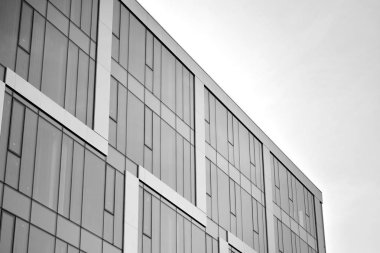 Çelik ve camdan yapılmış, mavi gökyüzü olan modern ofis duvarı. Siyah ve beyaz.