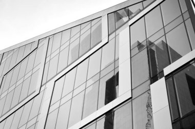 Çelik ve camdan yapılmış, mavi gökyüzü olan modern ofis duvarı. Siyah ve beyaz.