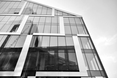 Çelik ve camdan yapılmış, mavi gökyüzü olan modern ofis duvarı. Siyah ve beyaz.