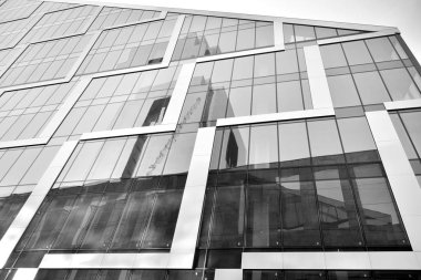 Çelik ve camdan yapılmış, mavi gökyüzü olan modern ofis duvarı. Siyah ve beyaz.