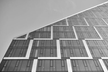 Çelik ve camdan yapılmış, mavi gökyüzü olan modern ofis duvarı. Siyah ve beyaz.