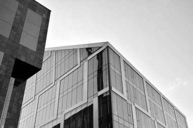 Çelik ve camdan yapılmış, mavi gökyüzü olan modern ofis duvarı. Siyah ve beyaz.