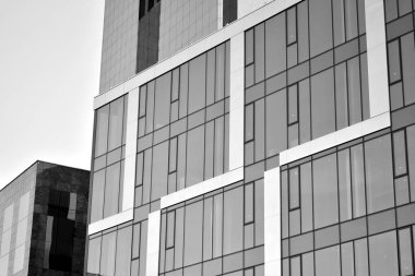 Çelik ve camdan yapılmış, mavi gökyüzü olan modern ofis duvarı. Siyah ve beyaz.