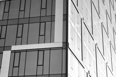 Çelik ve camdan yapılmış, mavi gökyüzü olan modern ofis duvarı. Siyah ve beyaz.