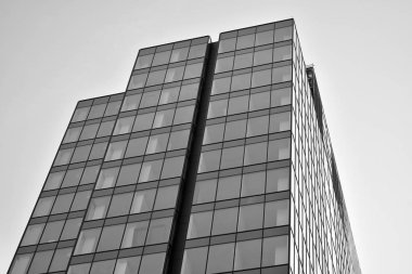 Çelik ve camdan yapılmış, mavi gökyüzü olan modern ofis duvarı. Siyah ve beyaz.