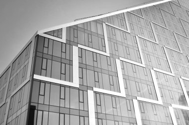 Çelik ve camdan yapılmış, mavi gökyüzü olan modern ofis duvarı. Siyah ve beyaz.