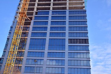 Yeni modern ofis gökdeleni bir şehirde inşa ediliyor. İnşaat sırasında cam elementlerin tamamlandığı ve beton olarak inşa edilen mimari ön cephe binası.