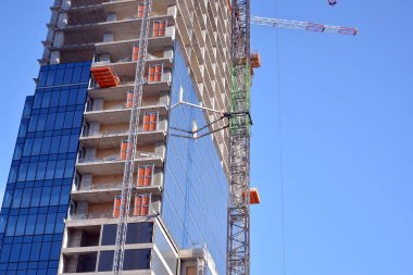 Yeni modern ofis gökdeleni bir şehirde inşa ediliyor. İnşaat sırasında cam elementlerin tamamlandığı ve beton olarak inşa edilen mimari ön cephe binası.