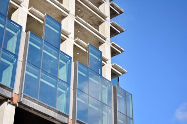 Yeni modern ofis gökdeleni bir şehirde inşa ediliyor. İnşaat sırasında cam elementlerin tamamlandığı ve beton olarak inşa edilen mimari ön cephe binası.