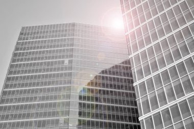 Çelik ve camdan yapılmış, mavi gökyüzü olan modern ofis duvarı. Güneş ışığıyla cam yüzey. Siyah ve beyaz.