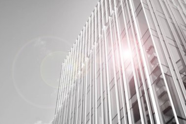 Çelik ve camdan yapılmış, mavi gökyüzü olan modern ofis duvarı. Güneş ışığıyla cam yüzey. Siyah ve beyaz.