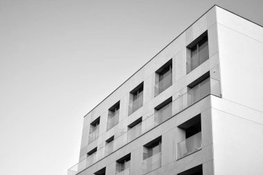 Modern apartman dairesinin dış kısmının ayrıntıları. Yeni lüks ev ve ev kompleksinin bir parçası. Güneş ışığıyla cam yüzey. Siyah ve beyaz.