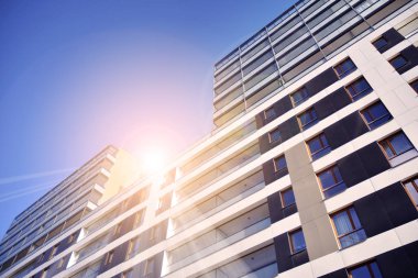 Güneş ışınları kentsel binalar üzerinde ışık etkisi yaratıyor. Düz binaları olan modern bir apartman dairesi. Yeni lüks ev ve ev kompleksinin ayrıntıları. 