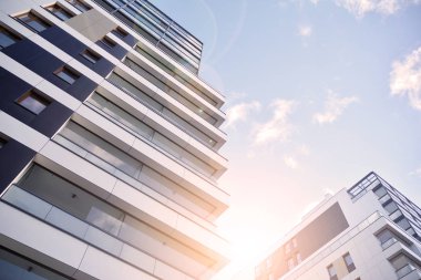 Güneş ışınları kentsel binalar üzerinde ışık etkisi yaratıyor. Düz binaları olan modern bir apartman dairesi. Yeni lüks ev ve ev kompleksinin ayrıntıları. 