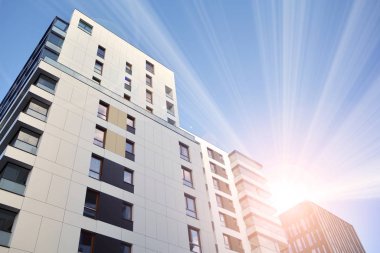 Güneş ışınları kentsel binalar üzerinde ışık etkisi yaratıyor. Düz binaları olan modern bir apartman dairesi. Yeni lüks ev ve ev kompleksinin ayrıntıları. 