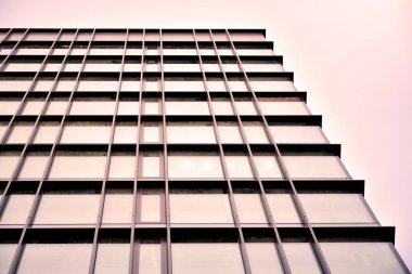 Güneş ışınları kentsel binalar üzerinde ışık etkisi yaratıyor. Modern ofis inşaatı, güneş ışığıyla kaplı cam yüzey. İş geçmişi. 