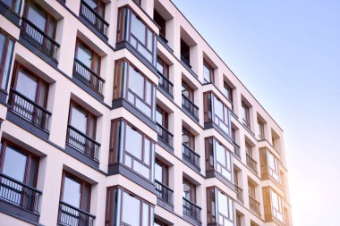 Güneş ışınları kentsel binalar üzerinde ışık etkisi yaratıyor. Düz binaları olan modern bir apartman dairesi. Yeni lüks ev ve ev kompleksinin ayrıntıları. 