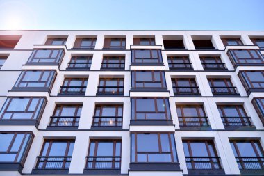Güneş ışınları kentsel binalar üzerinde ışık etkisi yaratıyor. Düz binaları olan modern bir apartman dairesi. Yeni lüks ev ve ev kompleksinin ayrıntıları. 