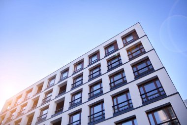 Güneş ışınları kentsel binalar üzerinde ışık etkisi yaratıyor. Düz binaları olan modern bir apartman dairesi. Yeni lüks ev ve ev kompleksinin ayrıntıları. 