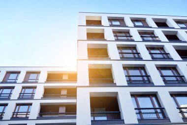 Güneş ışınları kentsel binalar üzerinde ışık etkisi yaratıyor. Düz binaları olan modern bir apartman dairesi. Yeni lüks ev ve ev kompleksinin ayrıntıları. 