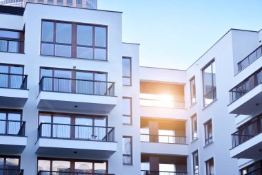 Güneş ışınları kentsel binalar üzerinde ışık etkisi yaratıyor. Düz binaları olan modern bir apartman dairesi. Yeni lüks ev ve ev kompleksinin ayrıntıları. 