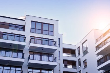 Güneş ışınları kentsel binalar üzerinde ışık etkisi yaratıyor. Düz binaları olan modern bir apartman dairesi. Yeni lüks ev ve ev kompleksinin ayrıntıları. 