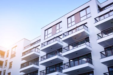 Güneş ışınları kentsel binalar üzerinde ışık etkisi yaratıyor. Düz binaları olan modern bir apartman dairesi. Yeni lüks ev ve ev kompleksinin ayrıntıları. 