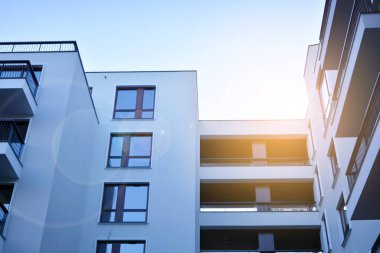 Güneş ışınları kentsel binalar üzerinde ışık etkisi yaratıyor. Düz binaları olan modern bir apartman dairesi. Yeni lüks ev ve ev kompleksinin ayrıntıları. 